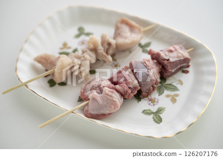 Pork skewers being prepared 126207176