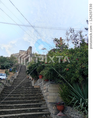 stone steps of the ancient fortress of Naryn-Kala, Derbent, Republic of Dagestan, Russia, pomegranate trees with ripe red pomegranates, cloudy summer day stone steps of the ancient fortress of Naryn-Kala, Derbent, Republic of Dagestan, Russia, pomegranate trees with ripe red pomegranates, cloudy summer day 126207330