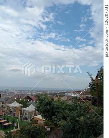 aerial view of Derbent, from the ancient fortress of Naryn-Kala, Republic of Dagestan, Russia, outdoor cafe tents decorated with garlands, blue cloudy sky aerial view of Derbent, from the ancient fortress of Naryn-Kala, Republic of Dagestan, Russia, outdoor cafe tents decorated with garlands, blue cloudy sky 126207331