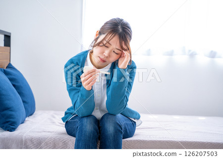A woman watching a thermometer A woman watching a thermometer 126207503