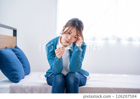 A woman watching a thermometer A woman watching a thermometer 126207504