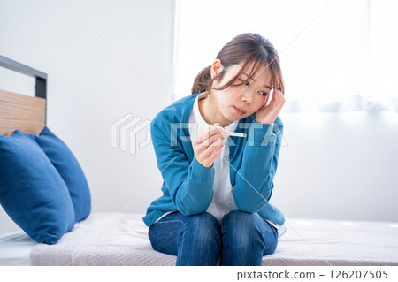 A woman watching a thermometer A woman watching a thermometer 126207505