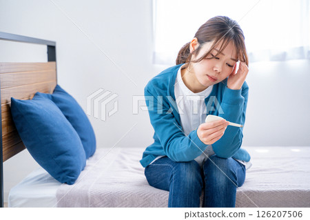 A woman watching a thermometer A woman watching a thermometer 126207506