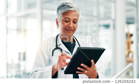Mature woman, doctor and research with tablet for medical discovery, news or healthcare service at hospital. Female person, health worker or executive browsing with technology for telehealth or app Mature woman, doctor and research with tablet for medical discovery, news or healthcare service at hospital. Female person, health worker or executive browsing with technology for telehealth or app 126208282