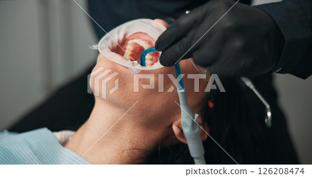 Hands, medical procedure and mouth of patient with dentist in office for checkup or surgery. Dental hygiene, filling or healthcare with medicine professional and woman at clinic for oral exam Hands, medical procedure and mouth of patient with dentist in office for checkup or surgery. Dental hygiene, filling or healthcare with medicine professional and woman at clinic for oral exam 126208474