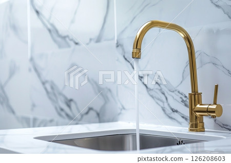 Kitchen sink. Modern new gold faucet, marble countertop. Stylish white sink, Brass faucets in light interior. Golden tap. Domestic Appliances. Gray clean bright household equipment. Contemporary style 126208603