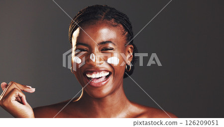 Happy, black woman and portrait with lotion in studio for skincare on a gray background. Face, female person or model with funny, smile or laughing for moisturizer, cream or facial treatment on space Happy, black woman and portrait with lotion in studio for skincare on a gray background. Face, female person or model with funny, smile or laughing for moisturizer, cream or facial treatment on space 126209051