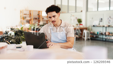 Pottery, creative and man in studio on laptop for inventory, logistics and art checklist of ceramic designs. Business, workshop and person on computer for planning, online order and store website Pottery, creative and man in studio on laptop for inventory, logistics and art checklist of ceramic designs. Business, workshop and person on computer for planning, online order and store website 126209346