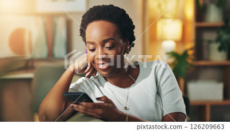 Black woman, happy and relax with phone in home for social media scroll, reading online news and ebook. Night, person and internet connection on sofa for dating site browse, blog post and research 126209663
