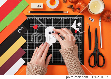 Glue eyes to the finished ghost silhouette. Autumn creativity for children. Handicrafts in love ghost. 126210194