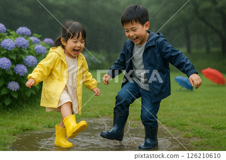 雨季期間,兄妹倆在公園的水坑玩耍,笑容滿面 雨季期間,兄妹倆在公園的水坑玩耍,笑容滿面 126210610
