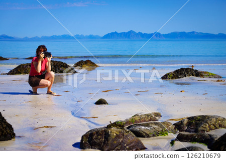 Woman take photo on beach, Lofoten Norway 126210679