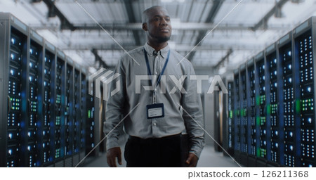 Big Data Center with Server Racks and Internet Servers: Specialist Walking In Warehouse 126211368