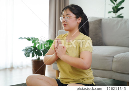 Asian woman meditate and practice yoga in the living room at home, home health care Asian woman meditate and practice yoga in the living room at home, home health care 126211843