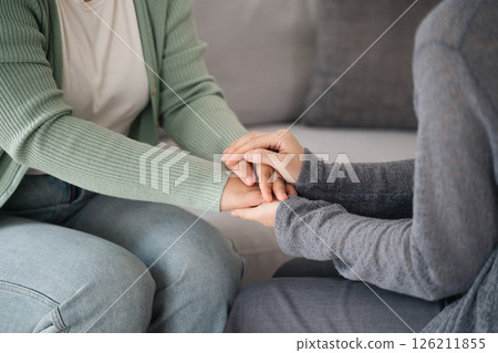Psychologist, friend or family holding hands to encourage patient with depression, anxiety 126211855
