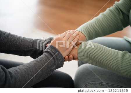 Psychologist, friend or family holding hands to encourage patient with depression, anxiety 126211856