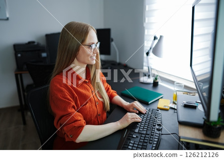 Focused professional enjoys working on her computer in a modern office 126212126
