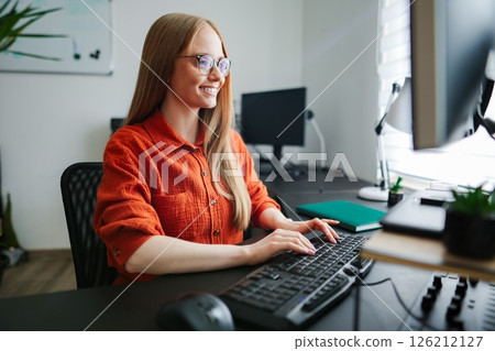 Focused woman working at home office with natural light 126212127