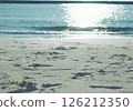 Waves and soap bubbles crashing on a sandy beach, photographed with a film camera 126212350