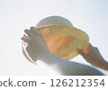 Straw hat and hand holding straw hat 126212354