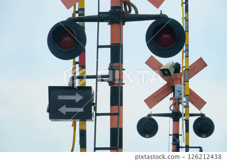 鐵路道口閘門、指示火車方向的箭頭和圓形紅色警示燈 126212438
