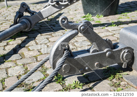 Fastening for anchor of the ship on a embankment in a port, near a river. Fastening for anchor of the ship on a embankment in a port, near a river. 126212550