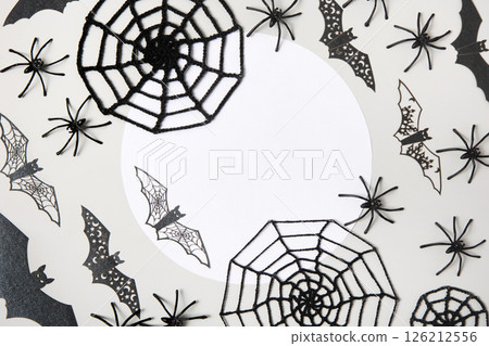 Halloween greeting card mockup with copy space. Halloween decorations, spiders, bats, knitted webs on gray background. Happy Halloween holiday concept. Flat lay, top view Halloween greeting card mockup with copy space. Halloween decorations, spiders, bats, knitted webs on gray background. Happy Halloween holiday concept. Flat lay, top view 126212556