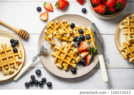 Belgian homemade waffles with strawberries, blueberries and honey Belgian homemade waffles with strawberries, blueberries and honey 126213813