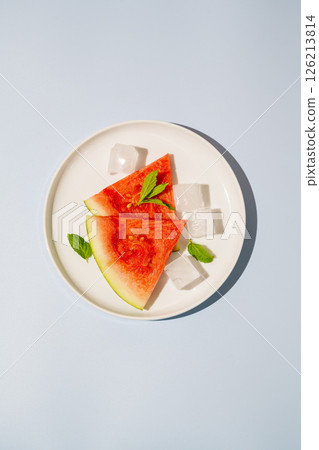 Watermelon triangle slices in a plate blue background Watermelon triangle slices in a plate blue background 126213814