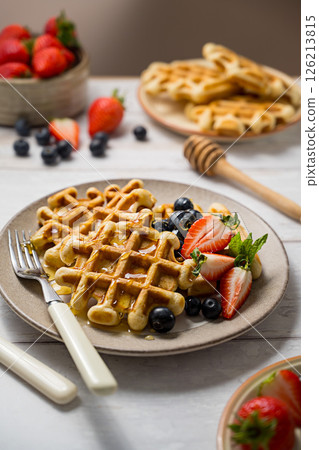Belgian homemade waffles with strawberries, blueberries and honey  126213815