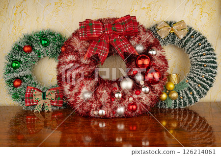 Lush pine needle wreath with red berries against the wall 126214061