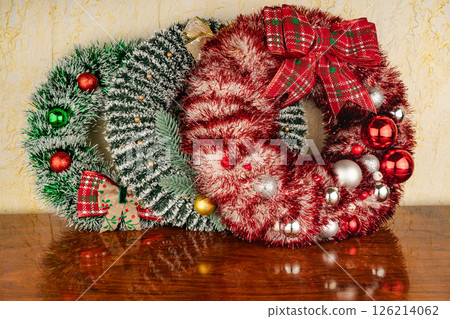 Lush pine needle wreath with red berries against the wall Lush pine needle wreath with red berries against the wall 126214062