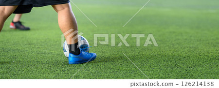 Soccer players in action on green grass field focusing on their legs and ball during game, showing movement and sports energy in close up view Soccer players in action on green grass field focusing on their legs and ball during game, showing movement and sports energy in close up view 126214138