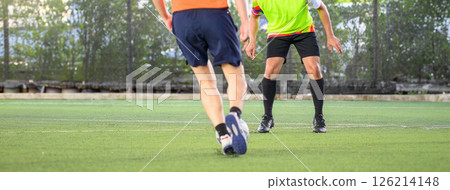 Soccer players in action during game on grass field focusing on their legs and ball, showing movement and competition in outdoor sports setting 126214148
