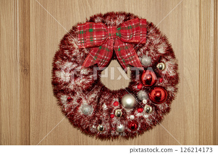 Decorated wreath with silver snowflakes, Christmas toys hangs on the door. Decorated wreath with silver snowflakes, Christmas toys hangs on the door. 126214173