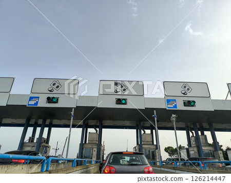Busy toll plaza bustling with vehicles under a blue sky during midday traffic in a vibrant city Busy toll plaza bustling with vehicles under a blue sky during midday traffic in a vibrant city 126214447