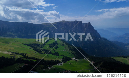 Breathtaking mountain landscape with lush green meadows under a vibrant blue sky in the Dolomites during midday Breathtaking mountain landscape with lush green meadows under a vibrant blue sky in the Dolomites during midday 126214528