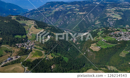 Majestic mountain valleys and charming villages nestled in the Northern Italy landscape during a serene summer afternoon 126214543