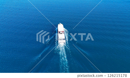 Sailing through clear azure waters on a bright sunny day near a picturesque coastline Sailing through clear azure waters on a bright sunny day near a picturesque coastline 126215178