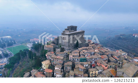 Majestic medieval castle overlooking quaint village in foggy landscape during a tranquil afternoon Generative AI 126215213