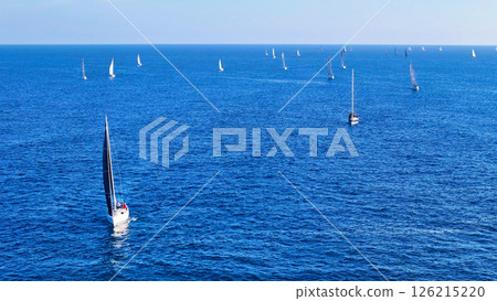 Sailing adventure unfolds on tranquil waters as multiple boats glide across the deep blue sea under a clear sky Generative AI 126215220