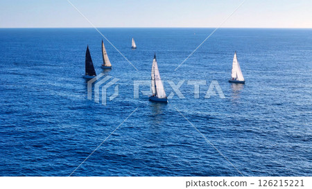 Eager sailboats glide gracefully across the azure waters of the ocean under a clear blue sky during a serene afternoon Generative AI 126215221