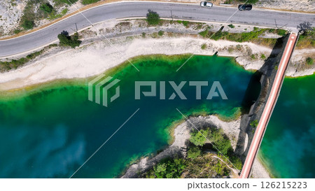Vibrant emerald waters shimmer beneath a winding road in a tranquil natural landscape during a sunny afternoon Generative AI Vibrant emerald waters shimmer beneath a winding road in a tranquil natural landscape during a sunny afternoon Generative AI 126215223