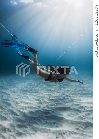 Freediver woman underwater. Freediving over white sand sea bottom, activity water sport. 126215275