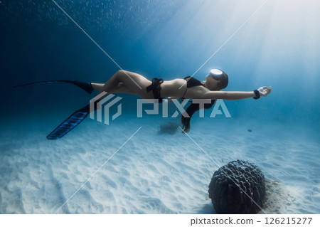 Woman freediver swims underwater. Freediving in tropical blue sea 126215277