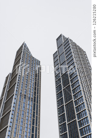 Tall Modern Glass Skyscrapers Reaching into Overcast Sky in Urban Setting Tall Modern Glass Skyscrapers Reaching into Overcast Sky in Urban Setting 126215280