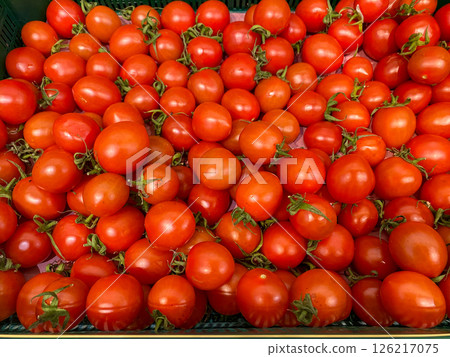 Red tomatoes lie on the counter at the store, fresh and ripe vegetables are sold at the market, healthy eating 126217075