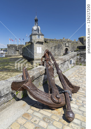 Rusty anchor resting on cobblestones with the Ville Close in Concarneau, France Rusty anchor resting on cobblestones with the Ville Close in Concarneau, France 126217200