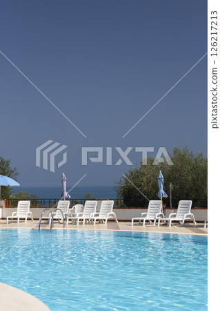 Inviting swimming pool overlooking the sea under a clear blue sky 126217213
