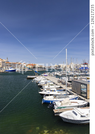 Boats mooring at the Mole Saint Louis in Sete, France, under a clear blue sky Boats mooring at the Mole Saint Louis in Sete, France, under a clear blue sky 126217235